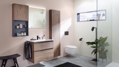 Pesupaikka, jossa on Geberitin kylpyhuonekalusteet, pesuallas ja peilikaappi pastellivärisellä seinällä.