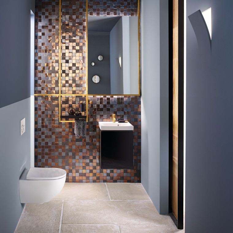 Näkymä moderniin vieras-WC:hen, jossa on Acanto-WC-istuin ja Acanto-pesuallas mosaiikkikuvioisen takaseinän edessä Näkymä moderniin vieras-WC:hen, jossa on Acanto-WC-istuin ja Acanto-pesuallas mosaiikkikuvioisen takaseinän edessä