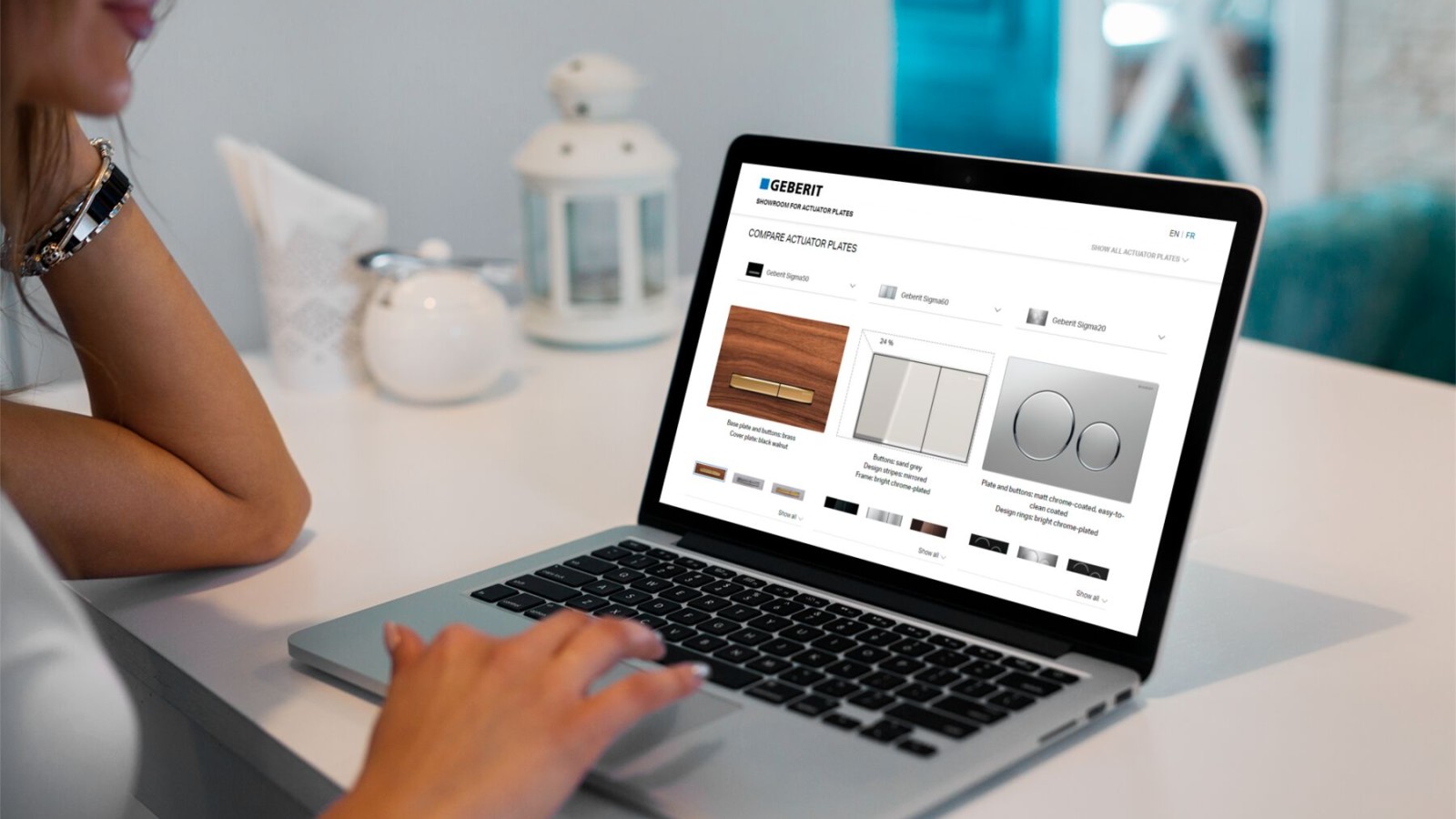 Nainen tutkuu Geberit-huuhtelupainikkeiden Onlinenäyttelyä tietokoneellaan