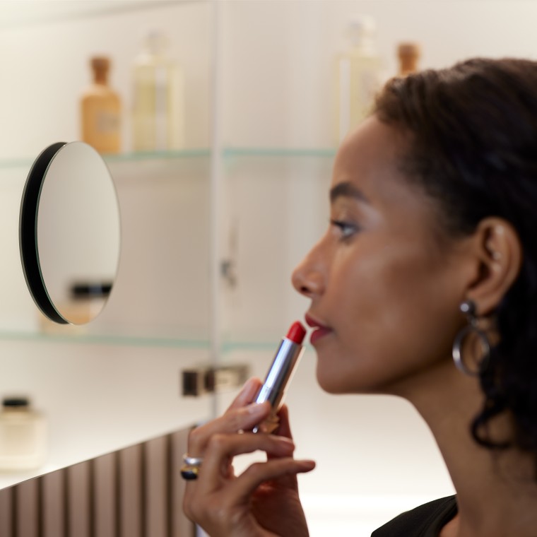 Nainen meikkaamassa suurennuspeilin avulla