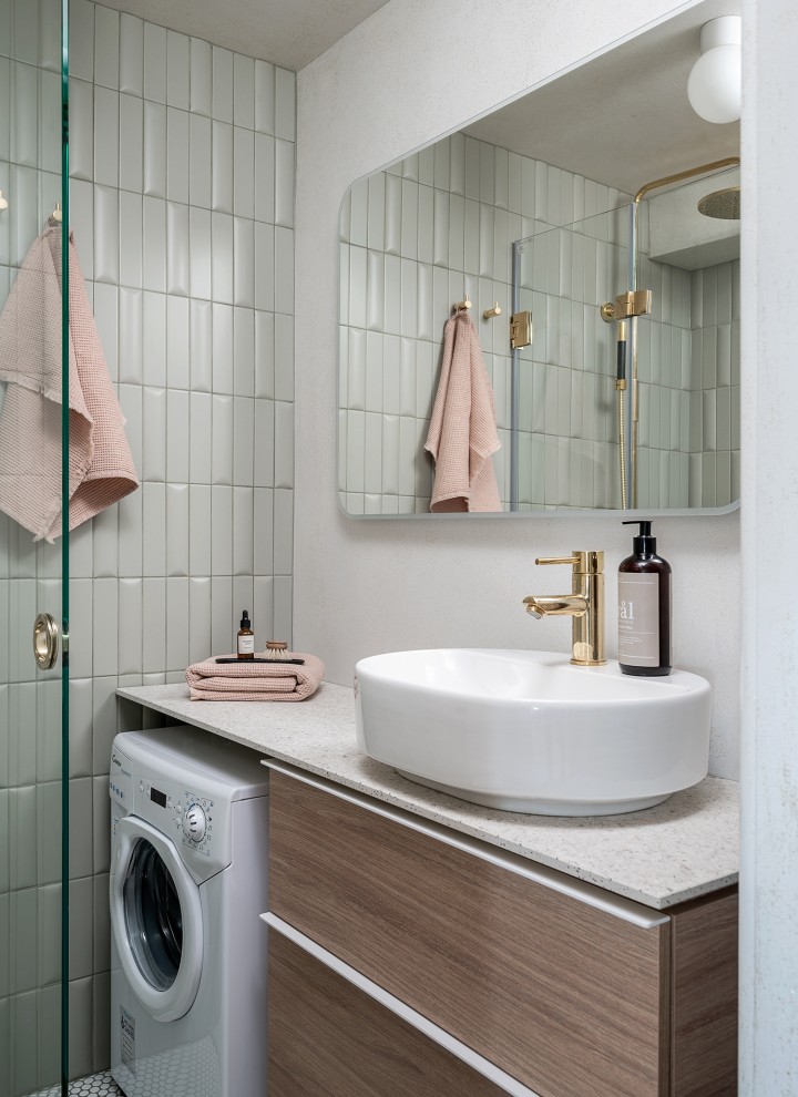 Jälkeen-kuva pienestä kylpyhuoneesta, jossa on soikea VariForm-kylpyhuonesarjan pesuallas ja tammipuun näköiset kylpyhuonekalusteet (© Meja Hynynen)