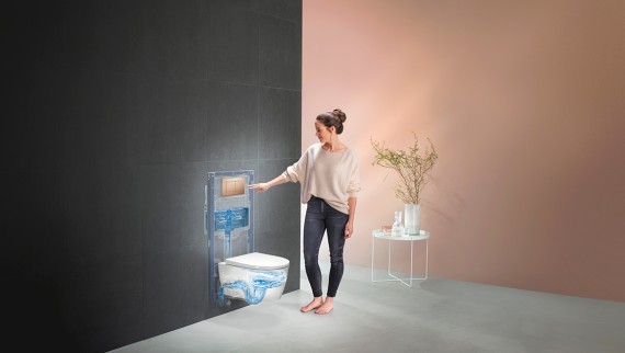 Nainen huuhtelee wc-istuimen, jossa on käytetty Geberit wc-ratkaisua (© Geberit)