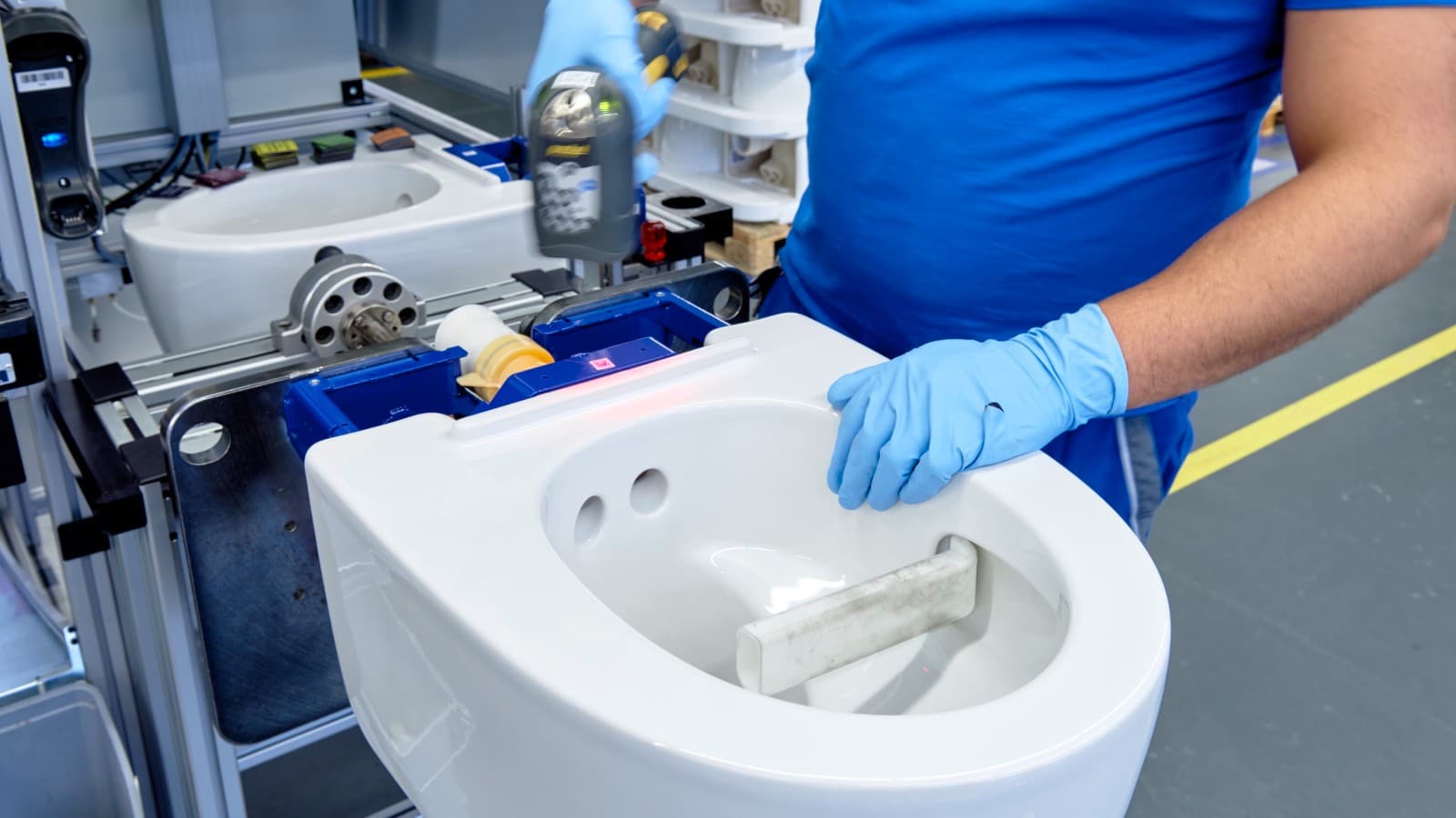 Geberitin työntekijä työskentelee Geberit AquaClean Mera -pesu-wc-istuimen parissa Jonassa Geberitin työntekijä työskentelee Geberit AquaClean Mera -pesu-wc-istuimen parissa Jonassa
